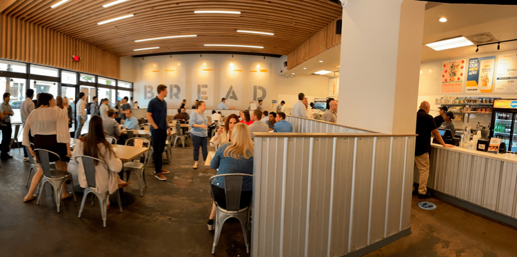 Customer Enjoying a Salad: A happy customer enjoying a vibrant salad in a cozy dining area of a salad franchise.